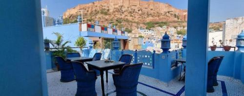 焦特布尔The Rajputana Haveli的阳台上的桌子和椅子，可以欣赏城市美景