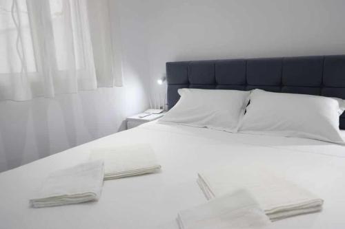 a white bed with a blue headboard and white pillows at Vaip House B in Berat