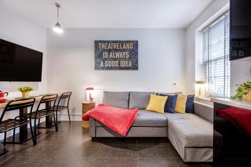 a living room with a couch and a table at Welcome London Theatreland House in London