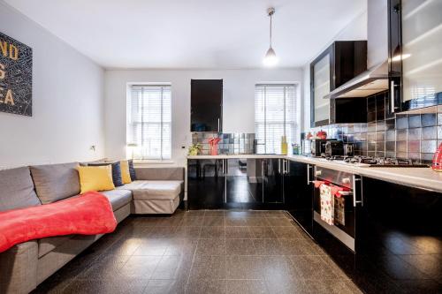 a living room with a couch and a kitchen at Welcome London Theatreland House in London