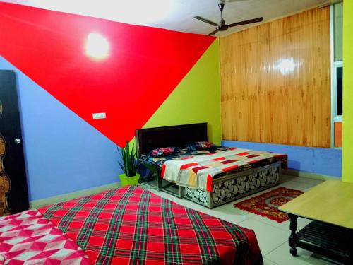 a room with two beds and a colorful wall at Stacy Guest House in Jīnd