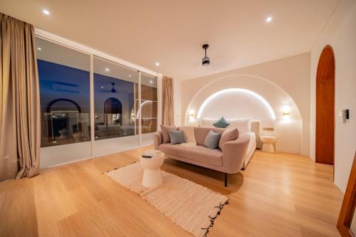 un salon avec un canapé et une grande fenêtre dans l'établissement Luxury 3BR Seseh Villa Ocean View with Rooftop Lounge & Beach Access, à Cemagi