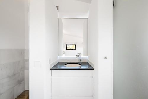 een witte badkamer met een wastafel en een spiegel bij Dalt Son Morro in Santa Margalida