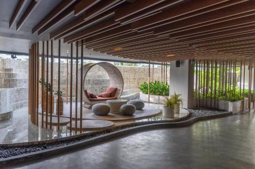 a lobby with a circular chair and a mirror at Bayphere Residence by Prop Hopper in Na Jomtien