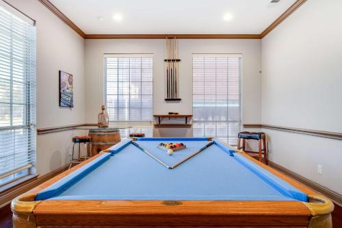 a pool table in a room with windows at King Suite House with Pool & BBQ in Rowlett