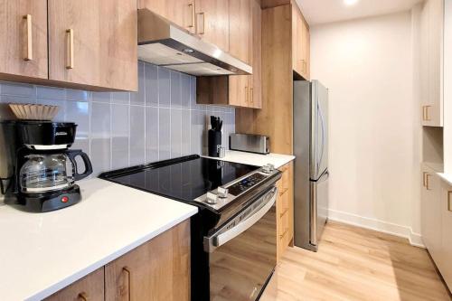 eine Küche mit Herd und Kühlschrank in der Unterkunft Corporate Stays Blum 2 Bedrooms in Brossard
