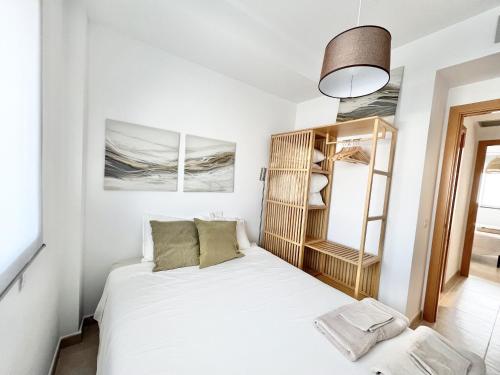 a small bedroom with a white bed and a mirror at Mediterranean Way - Miami Beach in Miami Platja