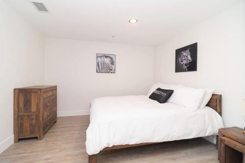 een slaapkamer met een wit bed en een houten dressoir bij Corporate Stays Junction 2 Bedrooms in Halifax