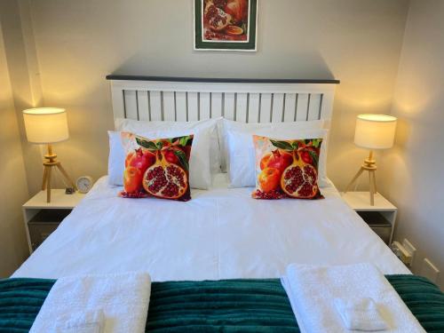 a bed with pomegranates and pillows on it at Granaat Pit - Paarl - Self Catering Apartment in Paarl