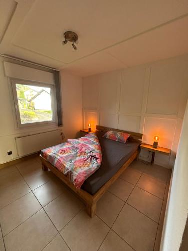 una camera con un letto e una finestra e due lampade di Ferienwohnung Hocheifelblick a Reifferscheid