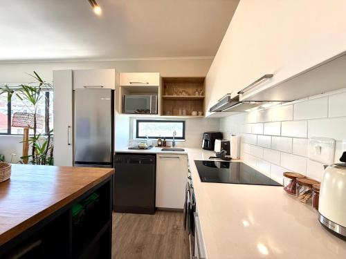 a kitchen with white cabinets and a black refrigerator at Mossel Bali - Mossel Cove in Mossel Bay