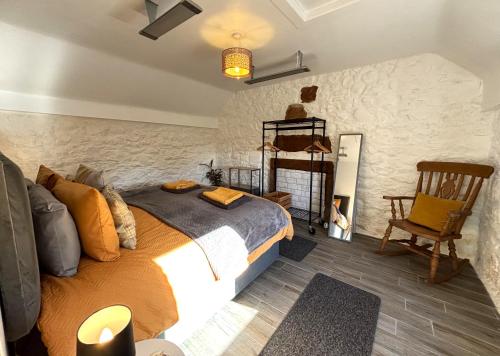 ein Schlafzimmer mit einem Kingsize-Bett und einem Stuhl in der Unterkunft Smiddy Cottage in Portmahomack