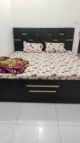 a bed with a black frame and pillows on it at Yamuna Kunj Homestay in Govardhan