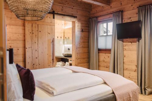 a bedroom with a bed in a wooden room at Hygna Chalets in Reith im Alpbachtal