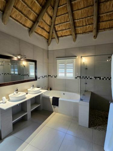 a large bathroom with two sinks and a bath tub at Montusi Mountain Lodge in Bonjaneni