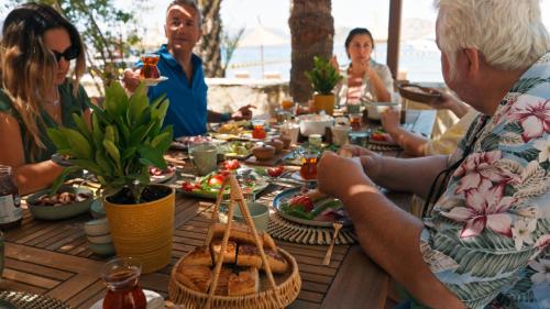 Un groupe de personnes assises autour d'une table avec de la nourriture dans l'établissement Villa Castelle, à Marmaris