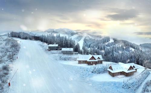 a snow covered village with houses on a mountain at Apartmány a Štúdiá Lúčky, SKI-IN SKI-OUT ,Chopok Jasná, Demänovská dolina in Demanovska Dolina