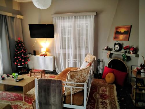 a living room with a christmas tree in the window at Mia Home in Artemida