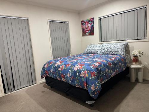 a bedroom with a bed with a colorful bedspread at Relaxing 3BR Home by Wattle Downs Reserve in Auckland