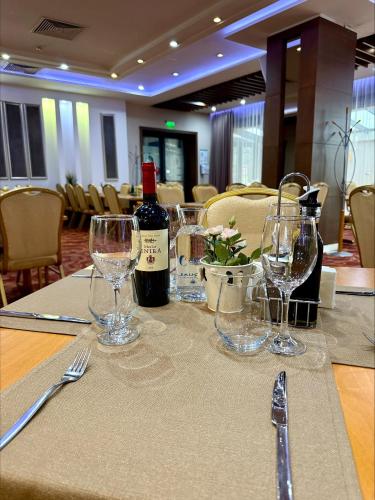 Central Hotel Sofia في صوفيا: طاولة مع كؤوس للنبيذ وزجاجة من النبيذ