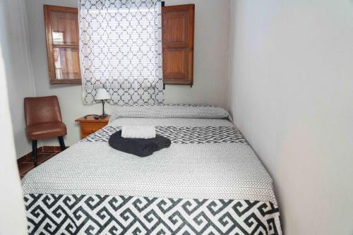 アルムニェーカルにあるCasa Finaの黒と白の毛布が掛けられたベッドのある寝室