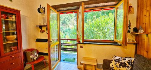 a room with a large window in a house at ALLA CASCATA in centro Branzi self check-in parcheggio gratuito coperto in Branzi
