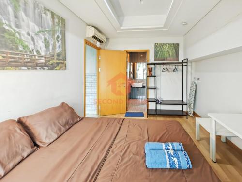 un grand lit dans une chambre avec une table dans l'établissement Strategic 2BR Capitol Apt Pool, Gym, Wi-Fi, à Jakarta