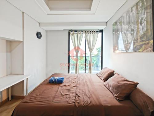 a large bed in a room with a window at Strategic 2BR Capitol Apt Pool, Gym, Wi-Fi in Jakarta