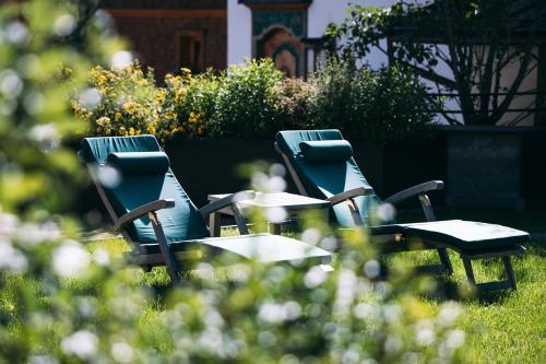 a group of chairs and tables in the grass at Hotel Aurora in Lech am Arlberg