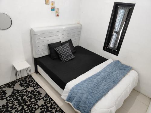 une petite chambre avec un lit et une fenêtre dans l'établissement Aurora villa Dieng, à Diyeng