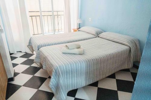 アルムニェーカルにあるCasa Finaのチェッカーフロアのベッドルーム1室(ベッド2台付)