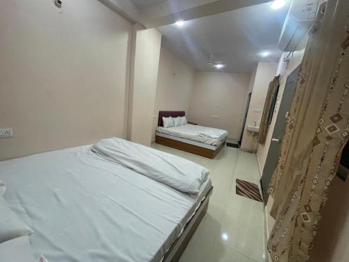una habitación de hospital con dos camas, una de ellas con una cama en Shree Shivay Residency, en Ujjain