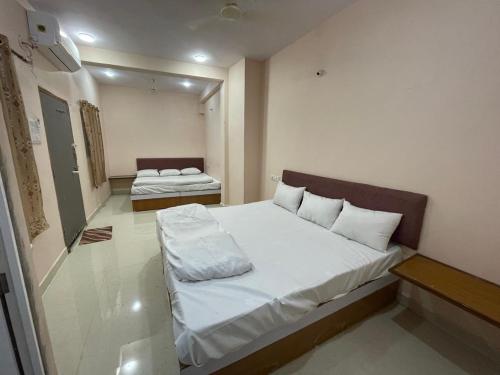 Una pequeña habitación con dos camas. en Shree Shivay Residency, en Ujjain