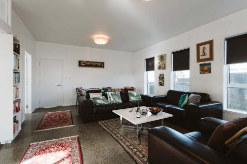 a living room with couches and a coffee table at Surf's Up - pet-friendly Fitzroy lifestyle home in New Plymouth