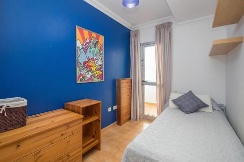 a blue bedroom with a bed and a wooden dresser at 3BR Buddha Penthouse - Solarium & Pool in Sardina