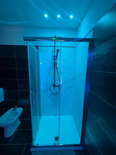 a bathroom with a glass shower with a toilet at Alba Camere Chiomonte in Chiomonte