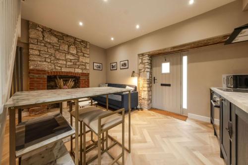 a kitchen with a table and a stone fireplace at The Old Loft House in Chew Stoke in Chew Stoke