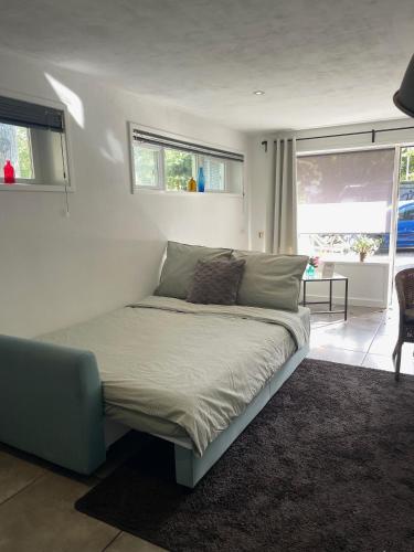 a bedroom with a bed in a room with windows at Gastensuite Eindhoven B&B Flora in Eindhoven
