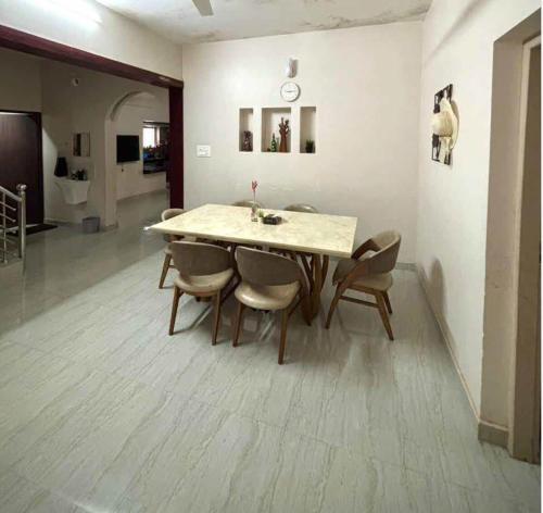 a dining room table and chairs in a room at Lenzo Home Stays in Kāsaragod