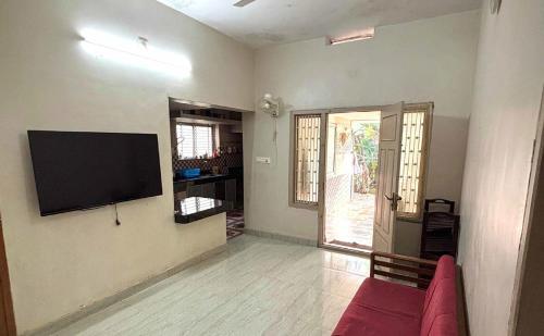 a living room with a flat screen tv on the wall at Lenzo Home Stays in Kāsaragod