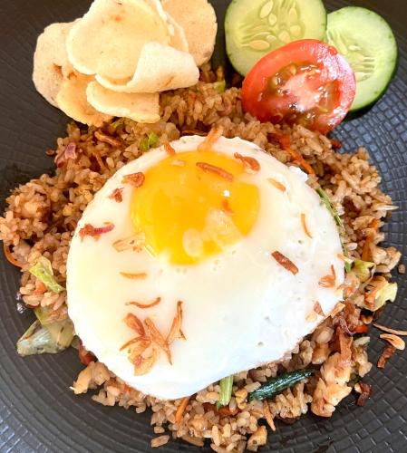 een bord eten met een gebakken ei op rijst bij Hillside bali in Kubupenlokan