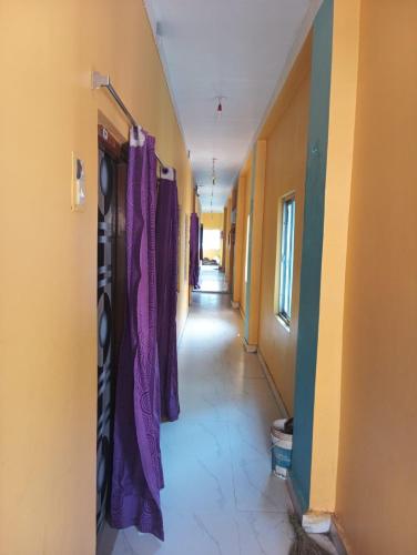 an empty hallway with purple curtains in a building at Sarat guest house in Digha