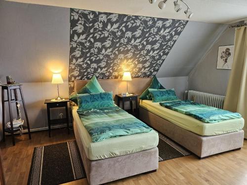 two beds in a small room with two lamps at Ferienwohnung Prinz in Lathen