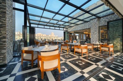 a restaurant with tables and chairs and a view of the city at Mileo Hotel The Palm in Dubai