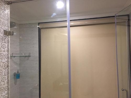 a shower with a glass door in a bathroom at Regency Kanchipuram by GRT Hotels in Kanchipuram