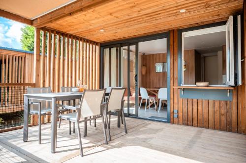 a dining area with a table and chairs on a patio at Rives d'Arc in Vallon-Pont-dʼArc