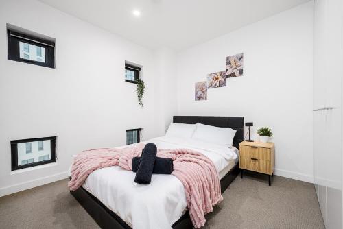 una camera da letto con un letto con una coperta rosa sopra di Southbank 2BR Apartment Steps from Crown Casino a Melbourne