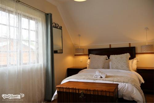 a bedroom with a large bed and a window at Amber & Birch in Dullstroom