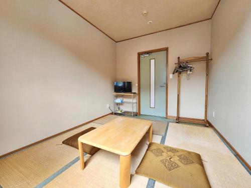 a room with a wooden table and a door at 名西旅館花 in Tokushima