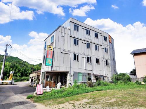 a large white building on the side of a street at 名西旅館花 in Tokushima